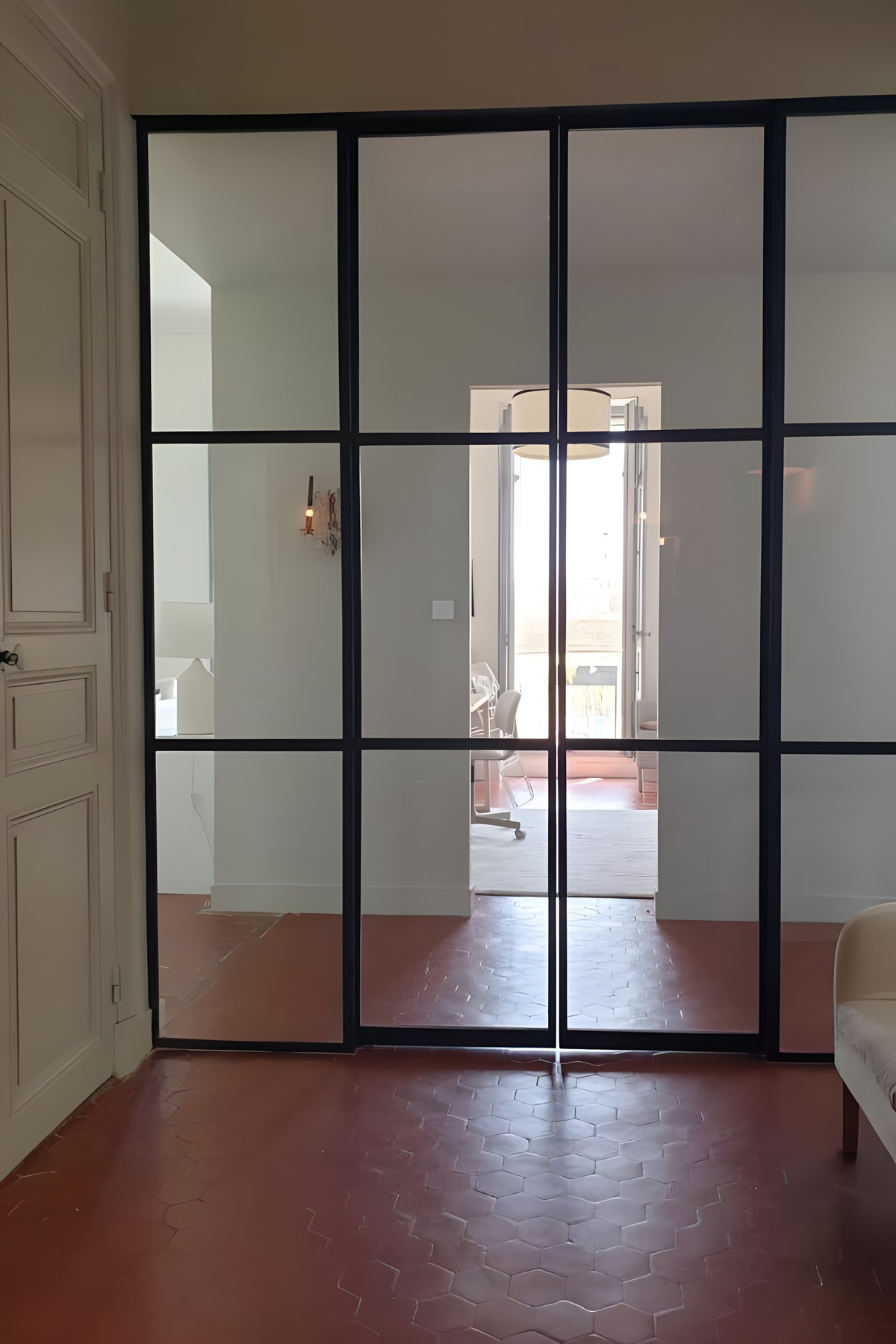 Verrière d'atelier ouvrant sur un sol en tomettes, appartement ancien d'Aix